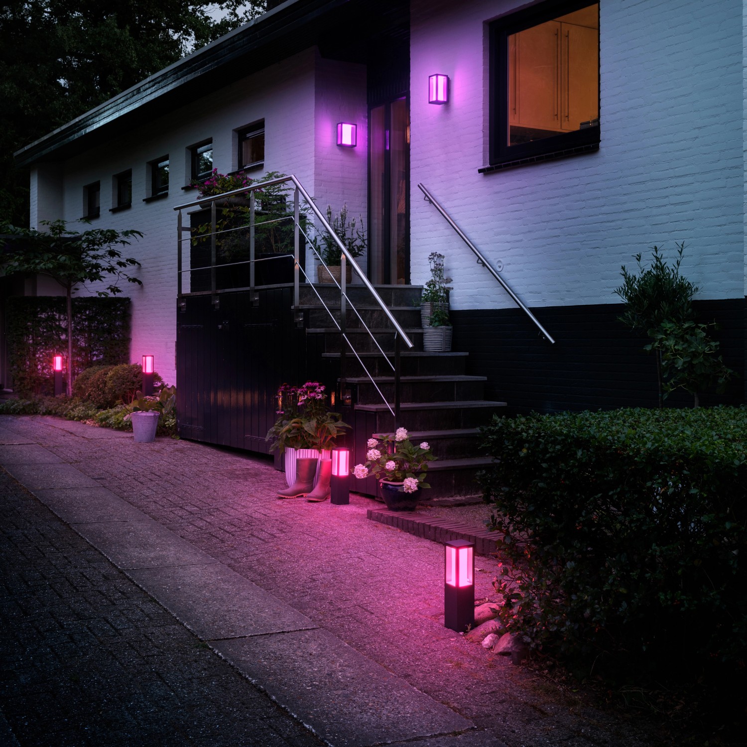 Philips Hue Impress Sockelleuchten in Farbe, beleuchten einen Hauseingang und Gartenwege.
