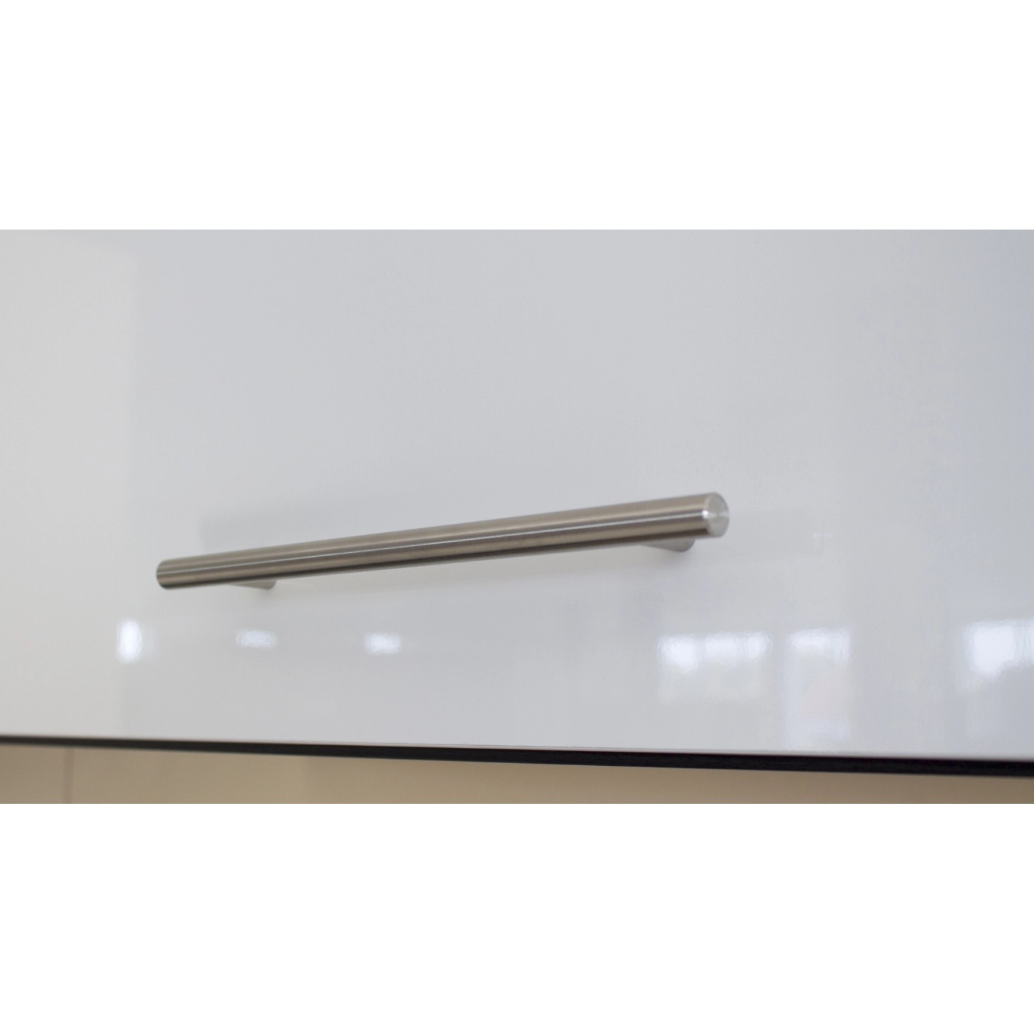 Detailaufnahme: Edelstahlgriff an weißer Hochglanz-Küchenfront der Respekta Premium Inselküche.