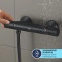 Schwarze Grohe QuickFix Thermostat-Brausebatterie Precision Start mit Wasserperlen.