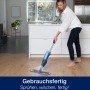 Frau reinigt Parkett mit Bona Spray Mop und Parkettreiniger Kartusche.