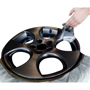 Felge mit Foliatec Sprühfolie in Matt-Schwarz, die abgezogen wird.