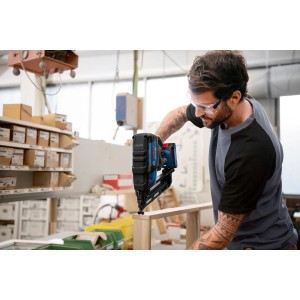Bosch Professional Akku-Holznagler GNH 18V-64 in Aktion beim Nageln von Holz.