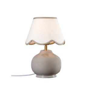 PR Home Nell Tischleuchte mit rundem, grauem Keramikfuß und hellem Stoffschirm mit geschwungenem Rand. Skandinavisches Design.
