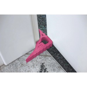 Schellenberg Türstopper Pink aus Kunststoff, eingesetzt zwischen Tür und Boden.