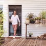 Mann geht durch tesa Magnetvorhang Anthrazit. Insektenschutz für Balkon- und Terrassentüren.