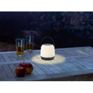 Schwarz-weiße LED-Akku-Tischleuchte Cecina (Ø 14 cm) auf Holztisch im Außenbereich.