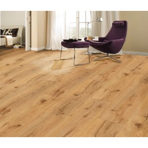 Verlegter Vinylboden Eiche Bologna Mittel im Wohnraum mit Sessel und Tageslicht.