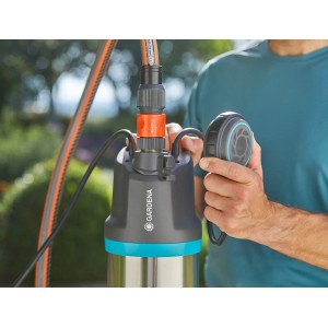 Gardena Tauch-Druckpumpe 5900/4 inox mit Schlauch und Bedienelement in der Hand.