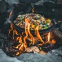 Petromax Dutch Oven FT9-T auf offenem Feuer mit Speise. Gusseisen Topf für Outdoor-Küche.