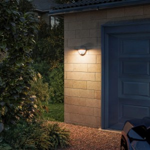 Anthrazitfarbene Philips Capricorn LED Außenwandleuchte mit Bewegungssensor an Hauswand.