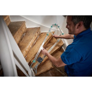 Mann benutzt wolfcraft Treppenlehre zum Ausmessen einer Treppe. Präzises Messwerkzeug für Renovierung.