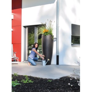 Frau befüllt Gießkanne an Garantia 2in1 Wasserbehälter 300 l Mocca mit Pflanzschale.