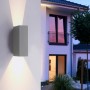 Graue Paul Neuhaus LED-Wandleuchte Block an Hauswand mit Lichtkegel nach oben und unten.