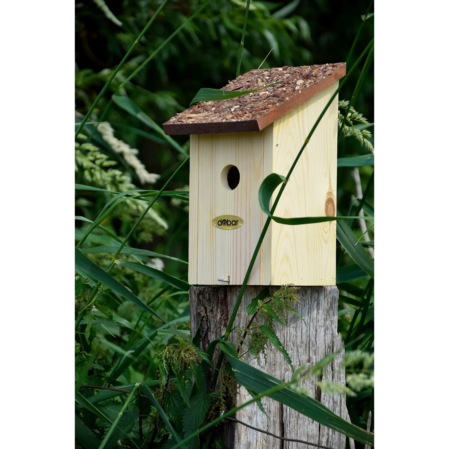 Nistkasten aus Kiefernholz mit Rindendach für Wildvögel im Garten.