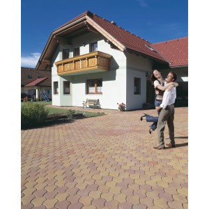 Verlegte Pflastersteine Heilbrunner Normalstein Herbstlaub auf einer Hofeinfahrt mit Haus und Paar.
