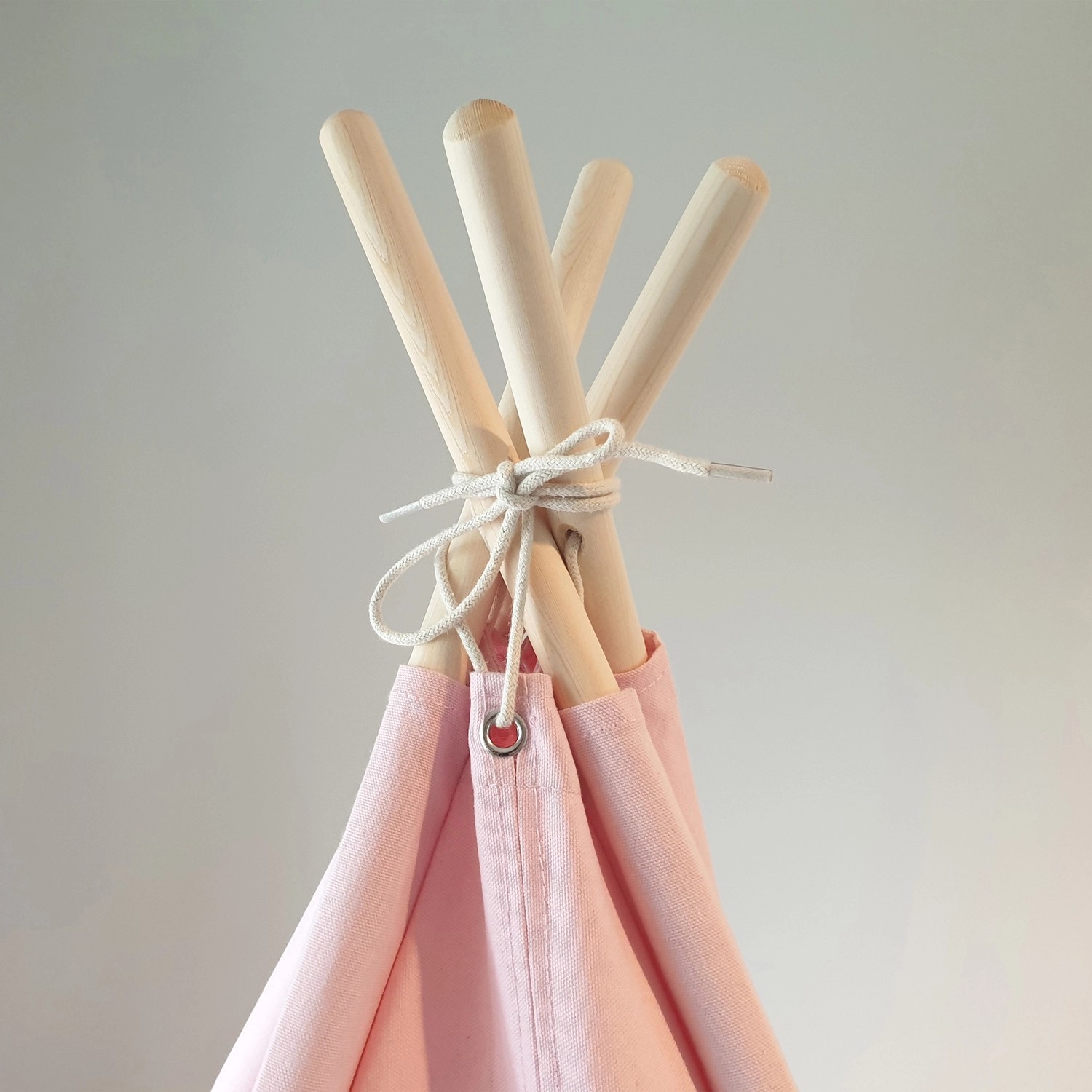 Detailaufnahme: Pastellrosa Sunny Tipi Zelt Alba mit Holzstäben und Schnur.