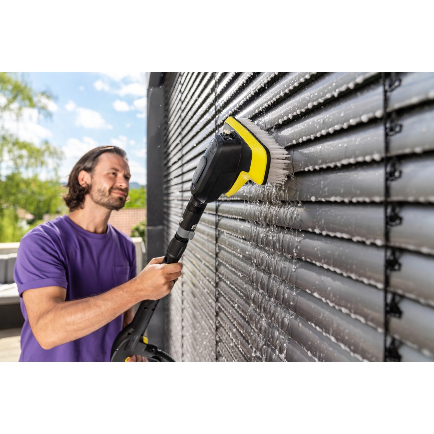 Kärcher WB 7 Plus 3-in-1 Waschbürste im Einsatz, reinigt eine Jalousie mit Wasser.