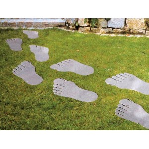 Graue Trittsteine in Fußform als Gehwegplatten im Garten.