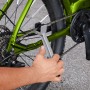 Fahrradpflege: Hand reinigt Kette eines grünen Fahrrads mit Bürste aus dem Eufab 10-teiligen Pflegeset.
