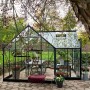 Halls Gewächshaus Garden Room, 12,9 m², grüne Aluminiumstruktur mit Sicherheitsglas, eingerichtet mit Tisch und Pflanzen.