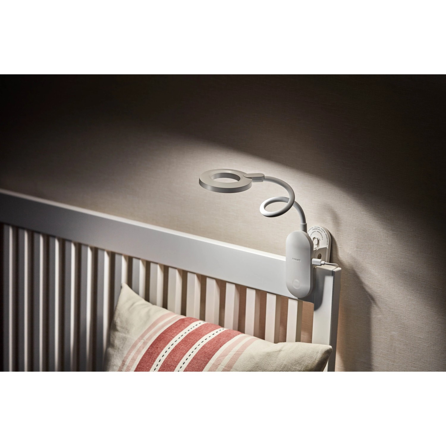 Philips Forys LED-Tischleuchte mit Clip am Bett befestigt. Akkubetriebene Leselampe.