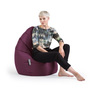Sitting Point Sitzsack Brava, 120 l, Aubergine. Frau sitzt entspannt auf dem lila Sitzsack.
