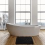 Schwarze MSV Badematte Kiesel (50x80 cm) vor Badewanne auf Holzboden.