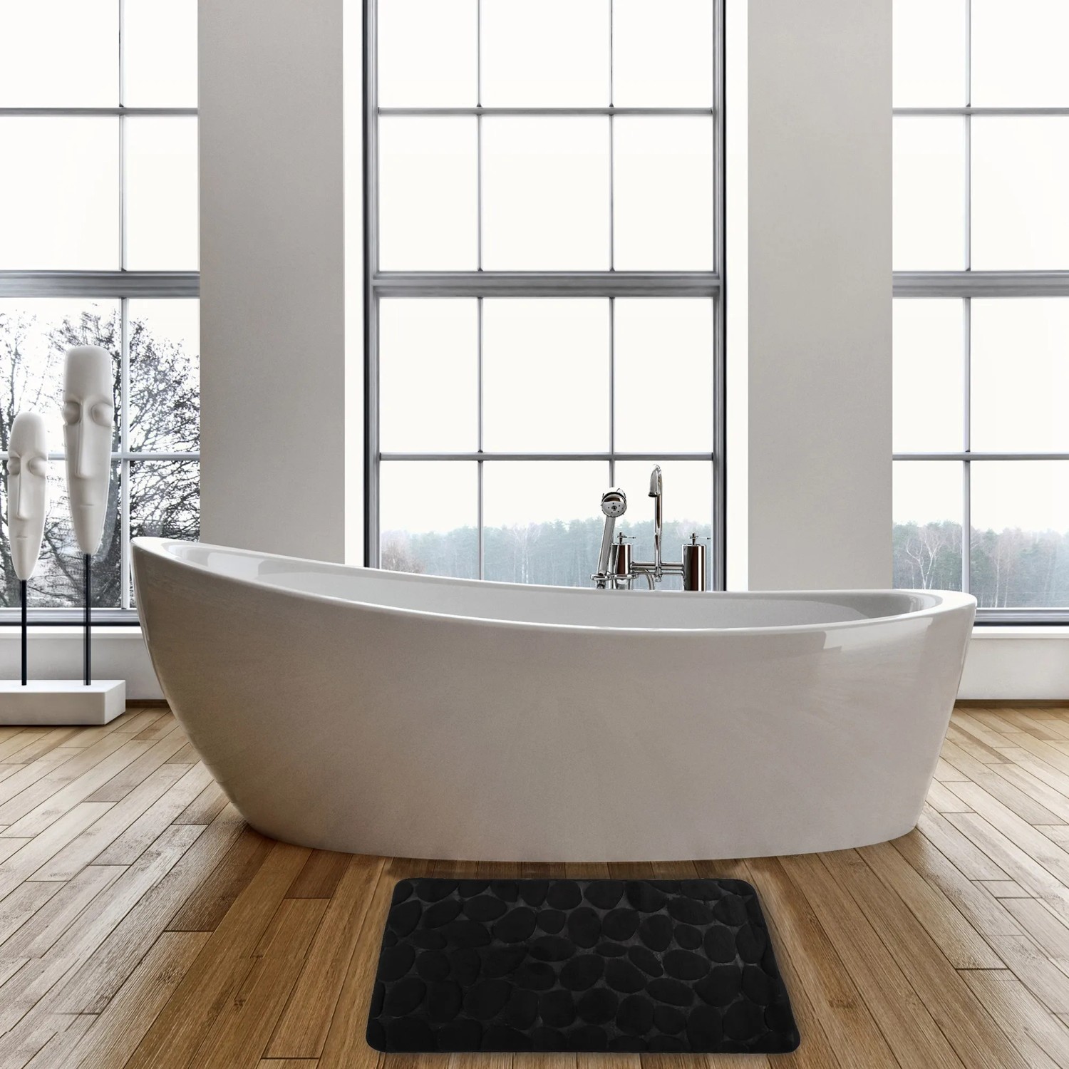 Schwarze MSV Badematte Kiesel (50x80 cm) vor Badewanne auf Holzboden.