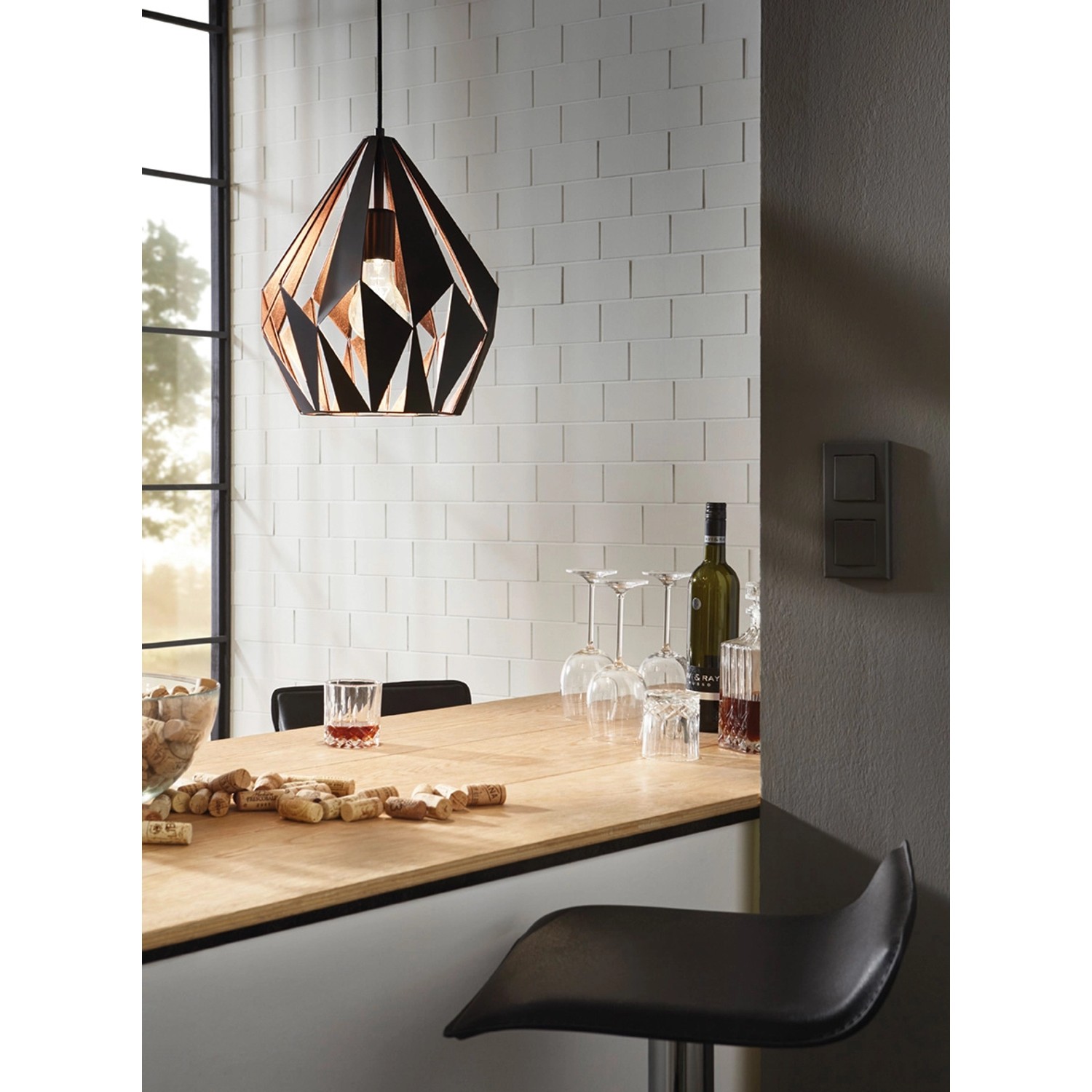 Moderne Eglo Pendelleuchte Carlton 1 in Schwarz-Kupfer über einer Bartheke.