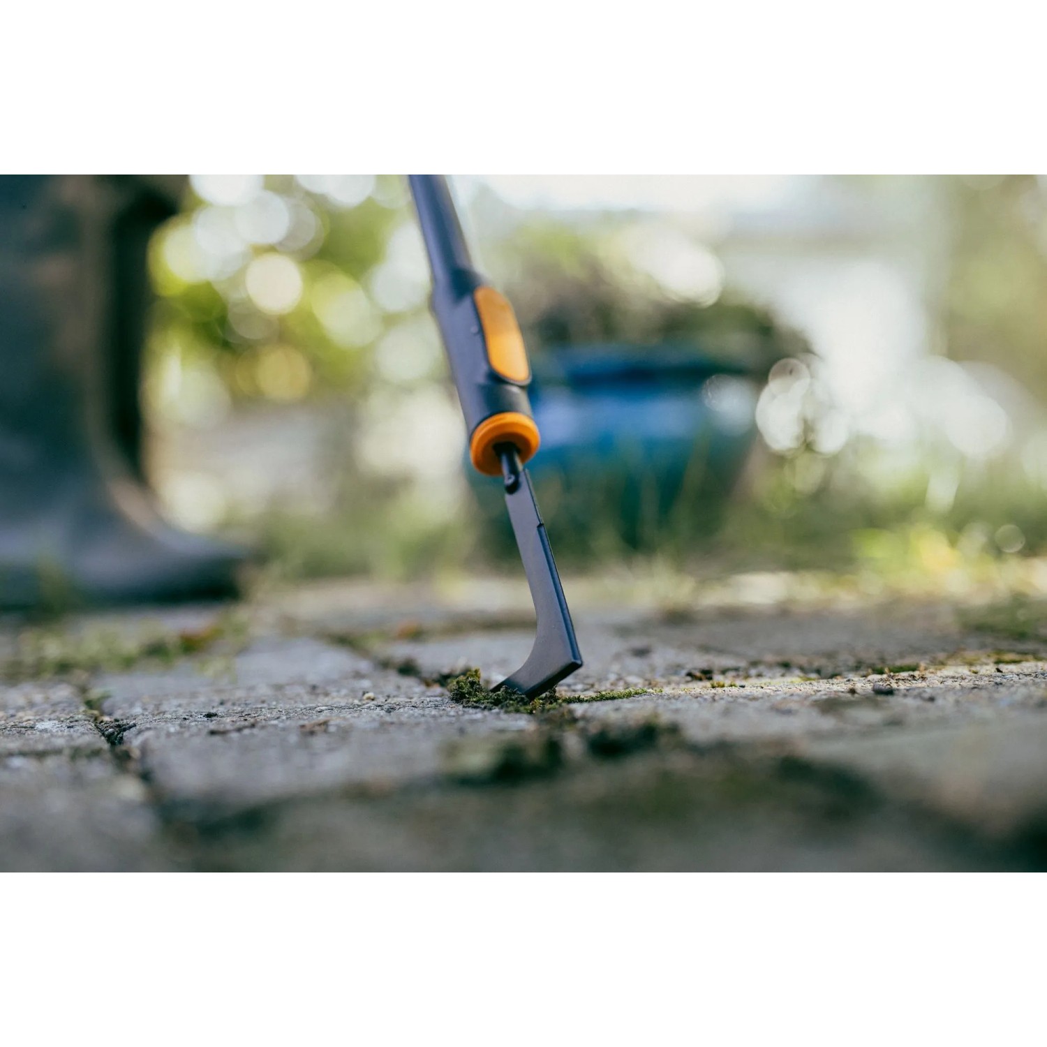 Fiskars Fugenkratzer OneClick in Aktion: Unkrautentfernung aus Pflasterfugen.