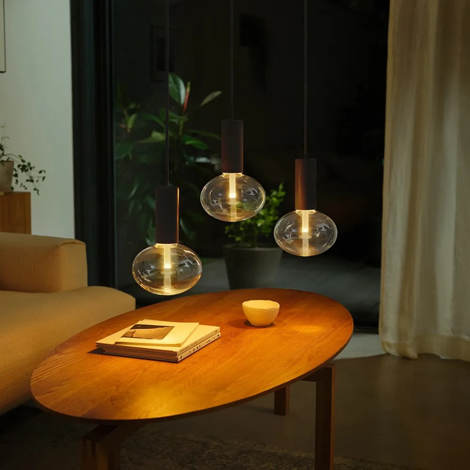 Drei Philips Hue E27 LED Lampen Lightguide Ellipse über einem Tisch. Smarte Beleuchtung im Wohnraum.