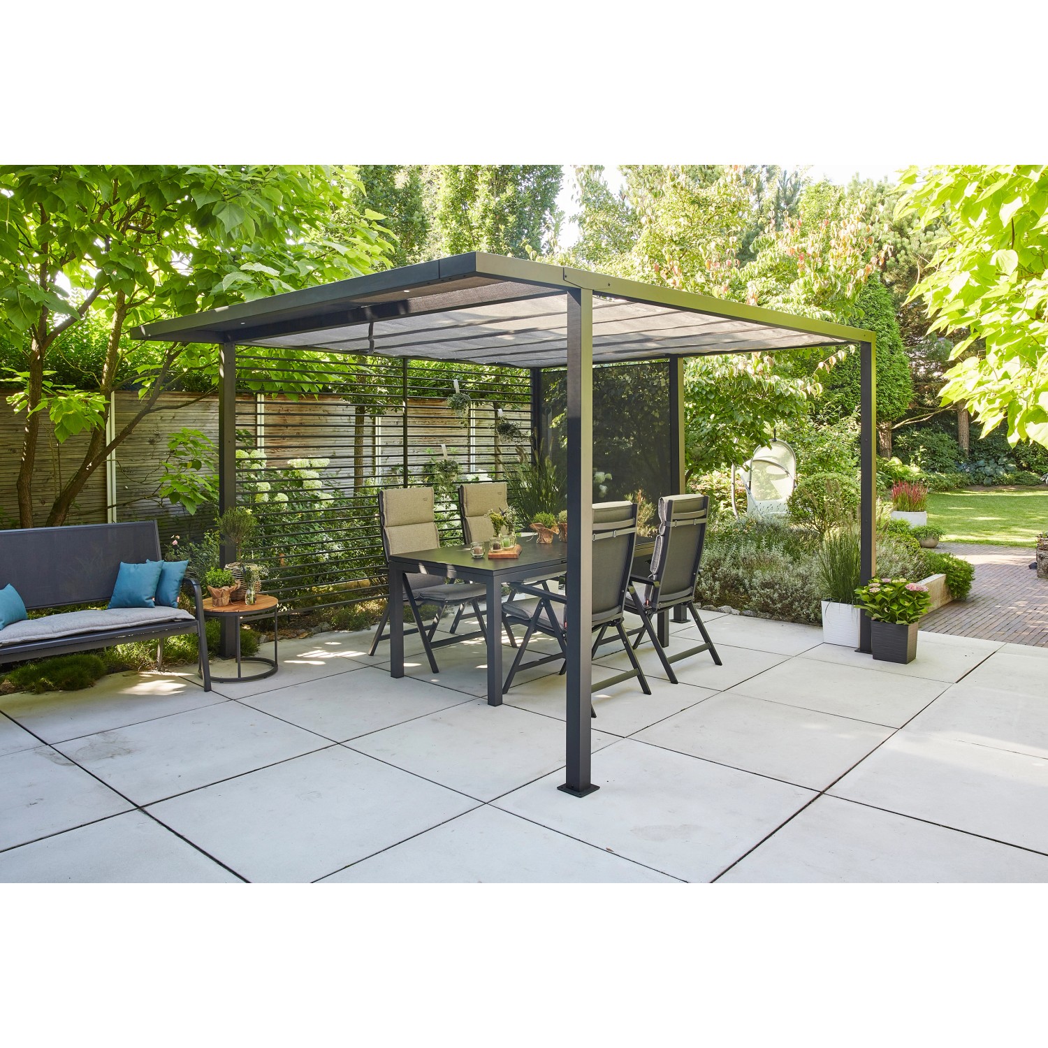 Siena Garden Pergola Schattenmanufaktur, 315x315x218 cm, anthrazit, mit Tisch und Stühlen im Garten.