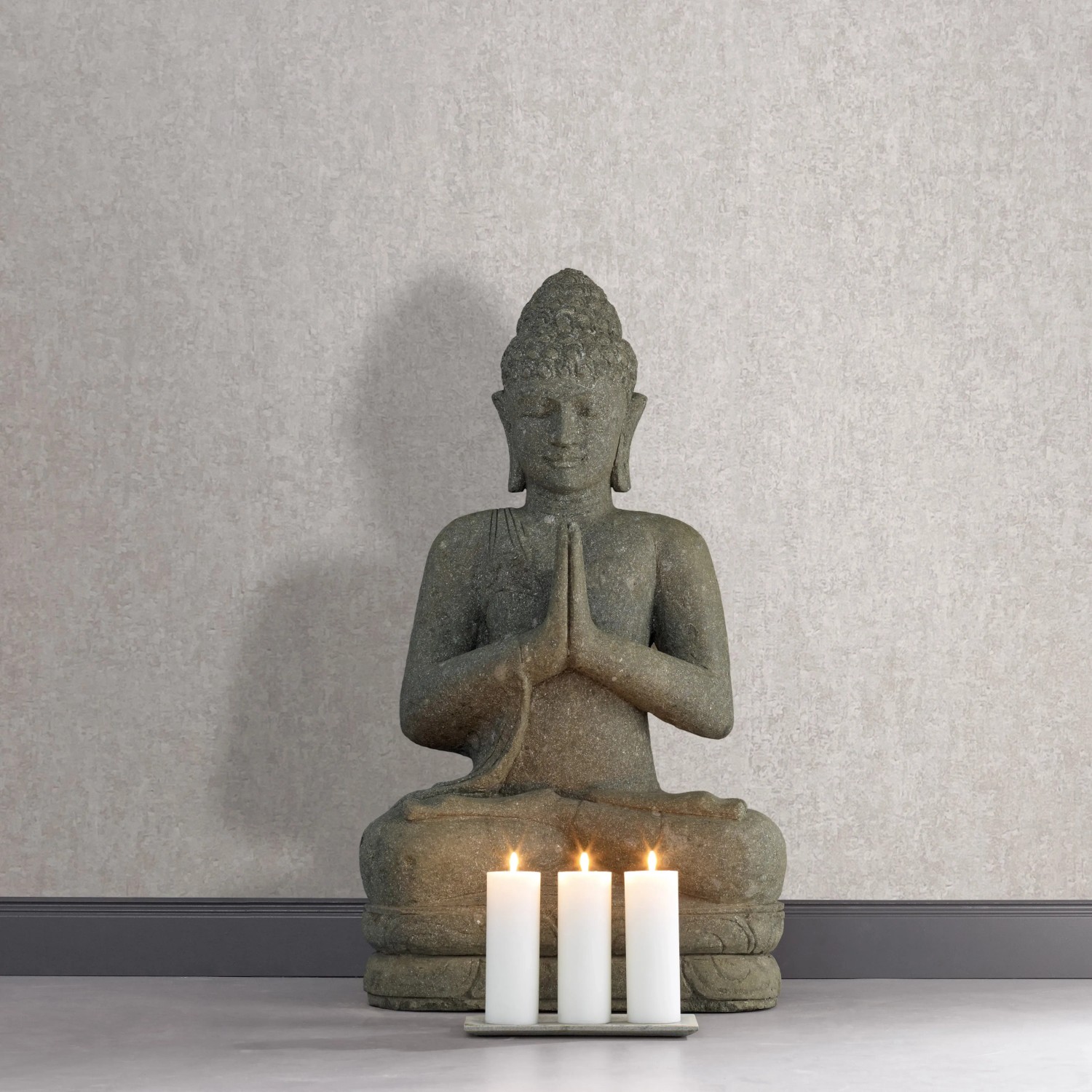 Moderne, matte Vliestapete in Betonoptik (weiß-grau) von Marburg. Im Raum mit Buddha-Statue und Kerzen.