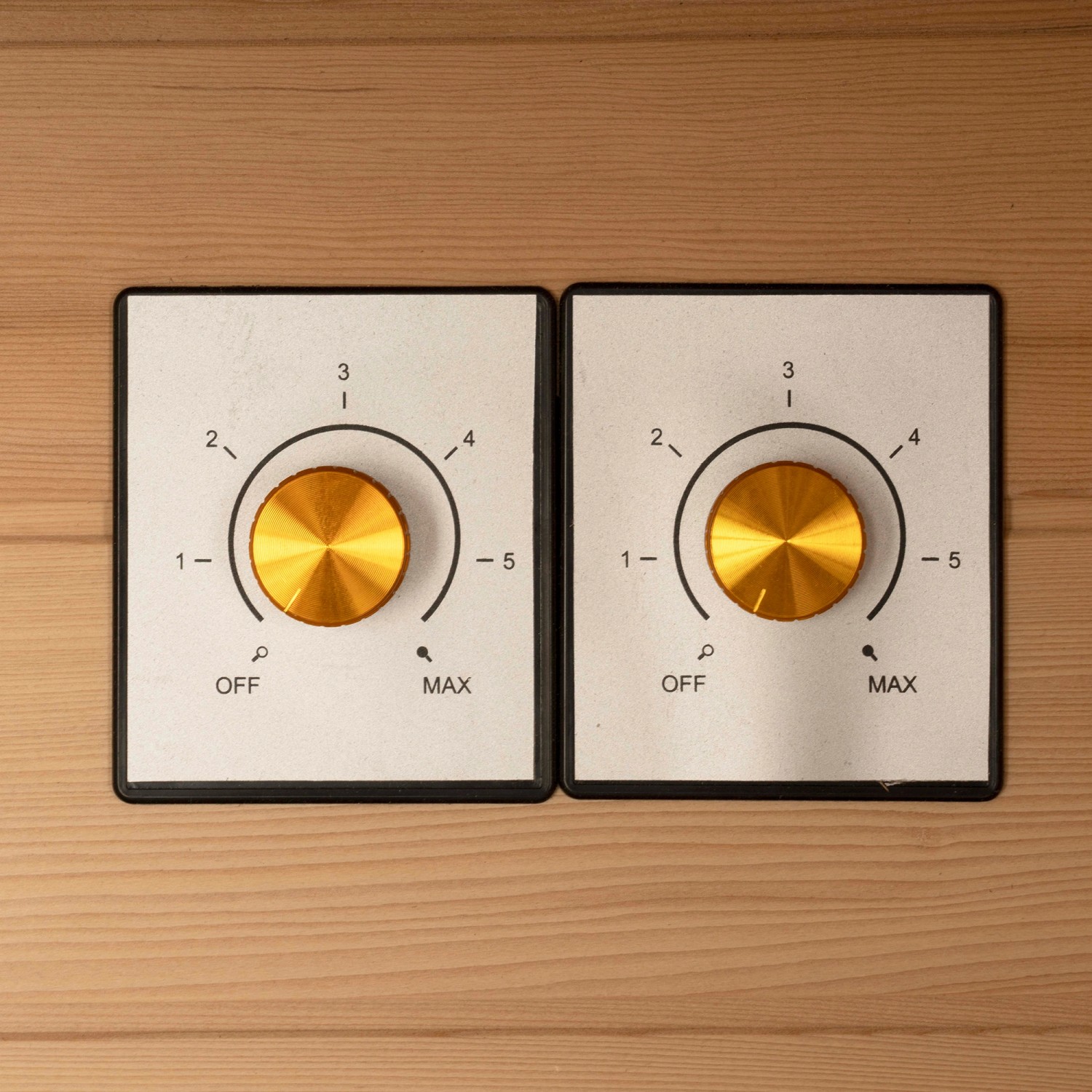 Detailaufnahme: Zwei goldene Drehregler zur Steuerung der Redsun Deluxe Infrarotkabine.