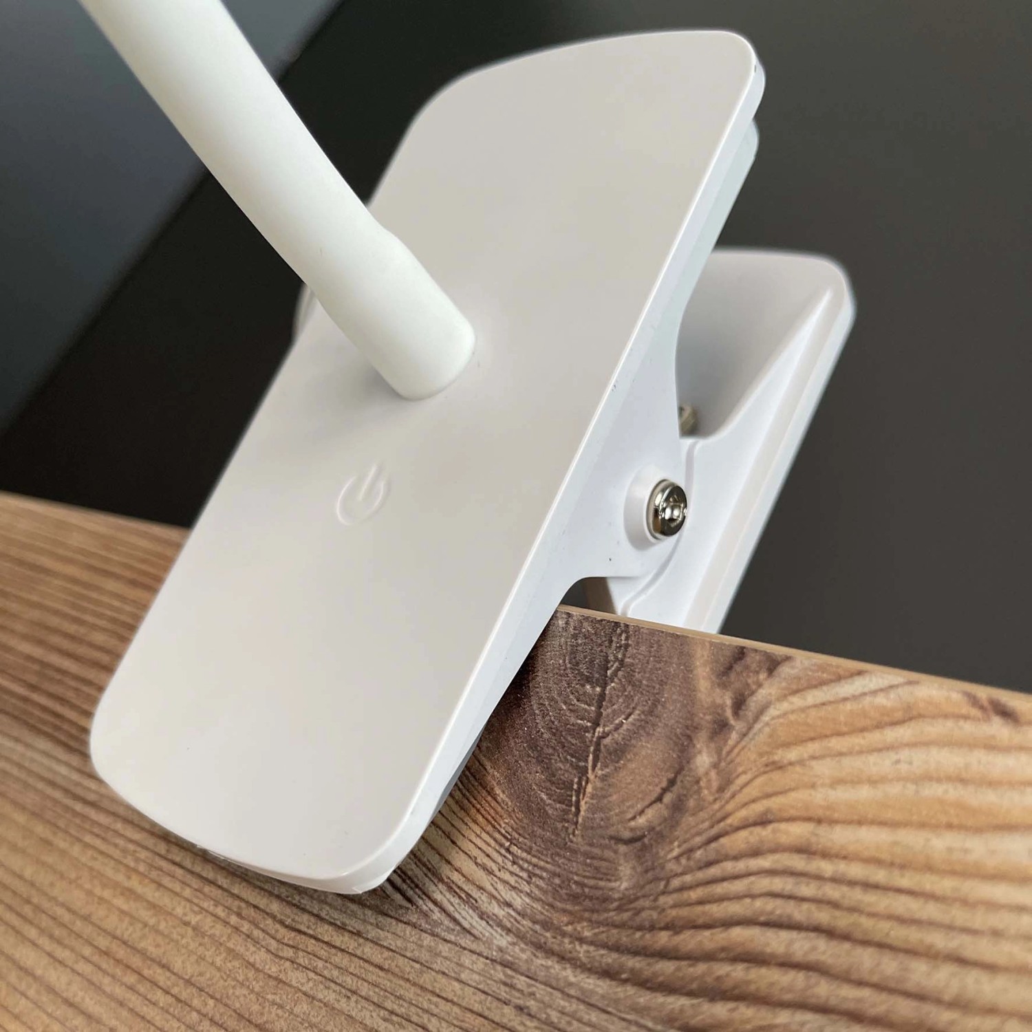 Detailaufnahme der weißen LED Klemmleuchte Luiz von Fischer & Honsel an einer Tischplatte.