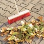 LUX Straßenbesen 40 cm mit Stiel und roten Borsten kehrt Laub auf Pflastersteinen.