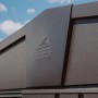 Nahaufnahme des dunkelgrau-metallic Biohort Metall-Gerätehaus Europa mit Logo vor blauem Himmel.
