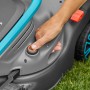 Detailaufnahme: Hand startet Gardena Akku-Rasenmäher PowerMax 32/18V.