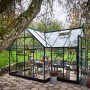 Halls Gewächshaus Garden Room, schwarzer Rahmen, Glas, mit Pflanzen und Dekoration im Garten.