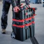 Gestapelte Einhell Werkzeugkoffer E-Case mit Werkzeug, transportiert von einer Person.