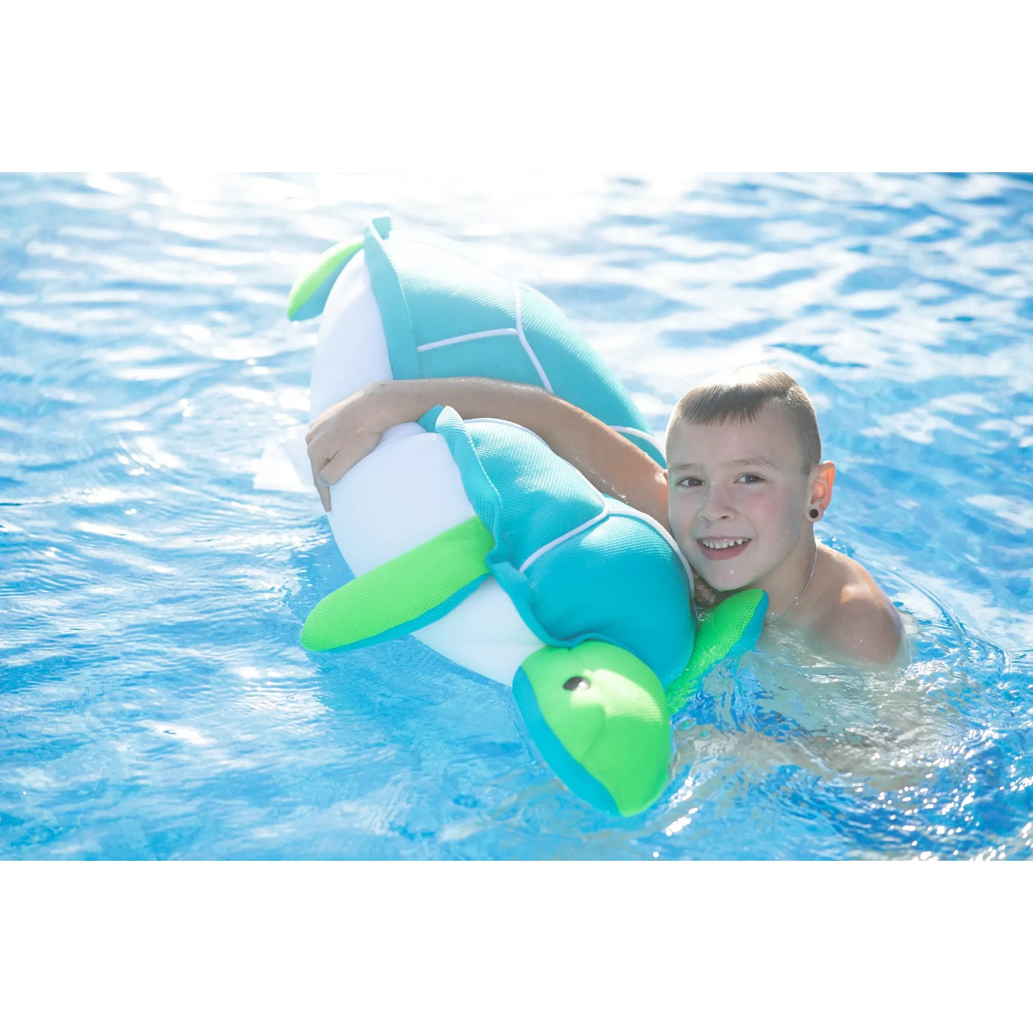 Junge umarmt blaue Westmann Pool Buddy Schildkröte im Wasser.