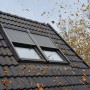 Solarbetriebener Rolladen aus Aluminium (CK02) für Dachfenster, teilweise geschlossen.