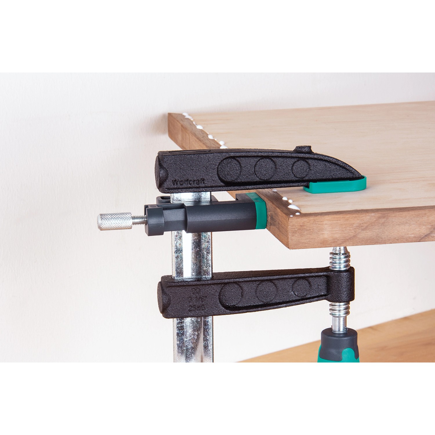 Wolfcraft Kantenspanner KS 24 (2 Stk.) im Einsatz zum Fixieren einer Holzplatte. Spannwerkzeug mit schwarzem Griff.