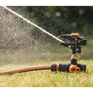 Fiskars Impulsregner mit Erdspieß bewässert Rasenfläche. Sprinkler-System für Garten.