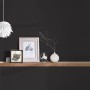 Schwarze Vliestapete Trendwall 2 Uni, kombiniert mit Deko-Elementen auf einem Holzregal.
