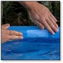CF Aqua Patch Pflaster zur Pool Reparatur wird auf einen blauen Pool aufgebracht.