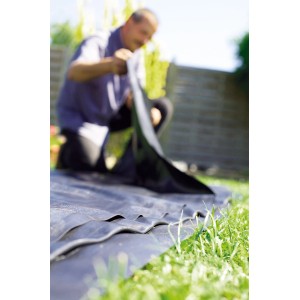 Schwarze Heissner PVC Teichfolie (1 mm) wird im Garten verlegt.