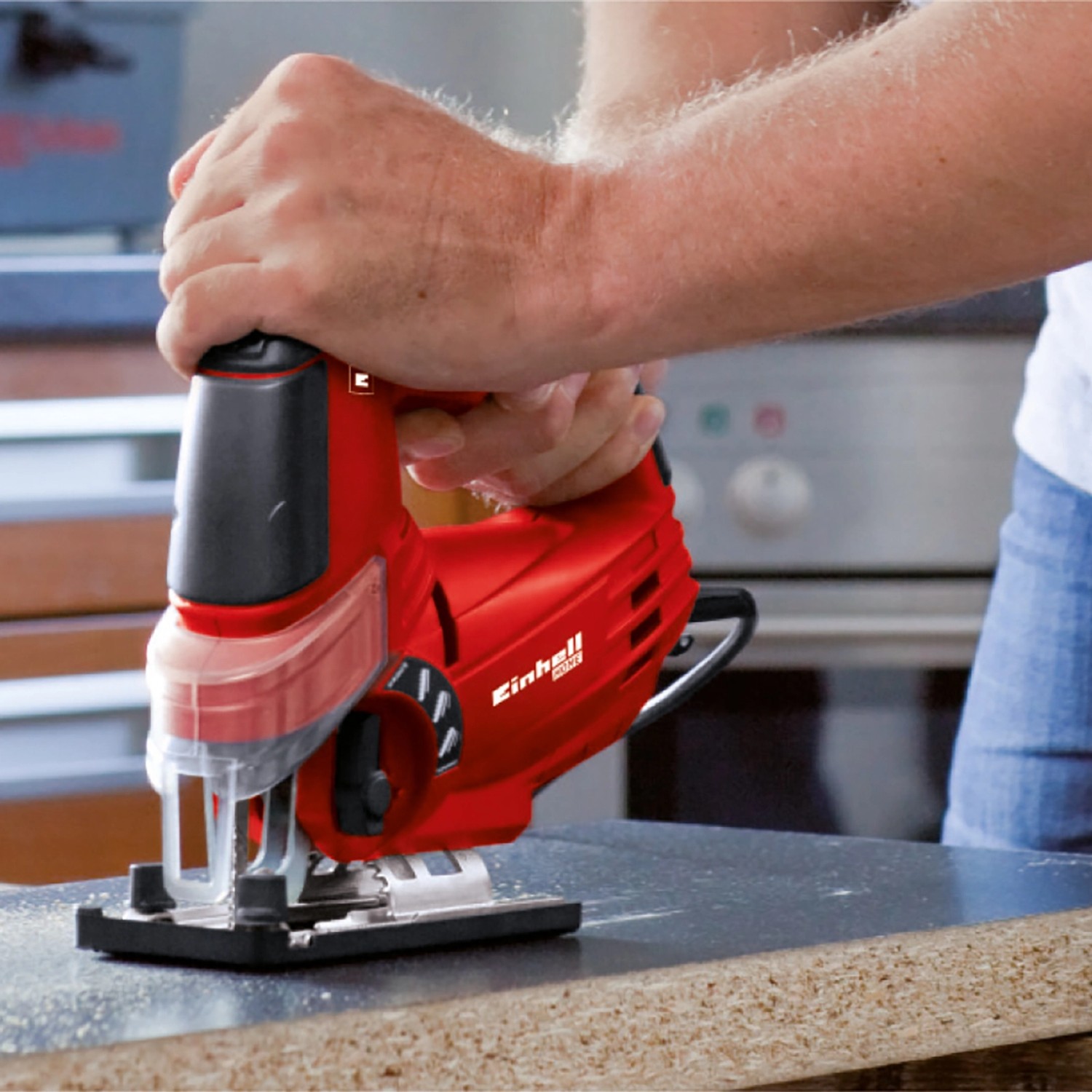 Einhell Akku-Stichsäge TE-JS 18 Li Solo beim Sägen von Holz. Rot, mit Spanreißschutz.