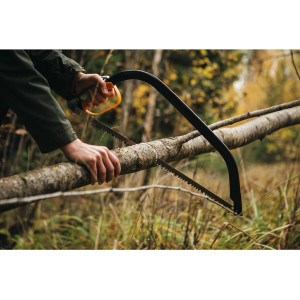 Fiskars Bügelsäge SW30 in Aktion: Eine Person sägt einen Ast im Garten.