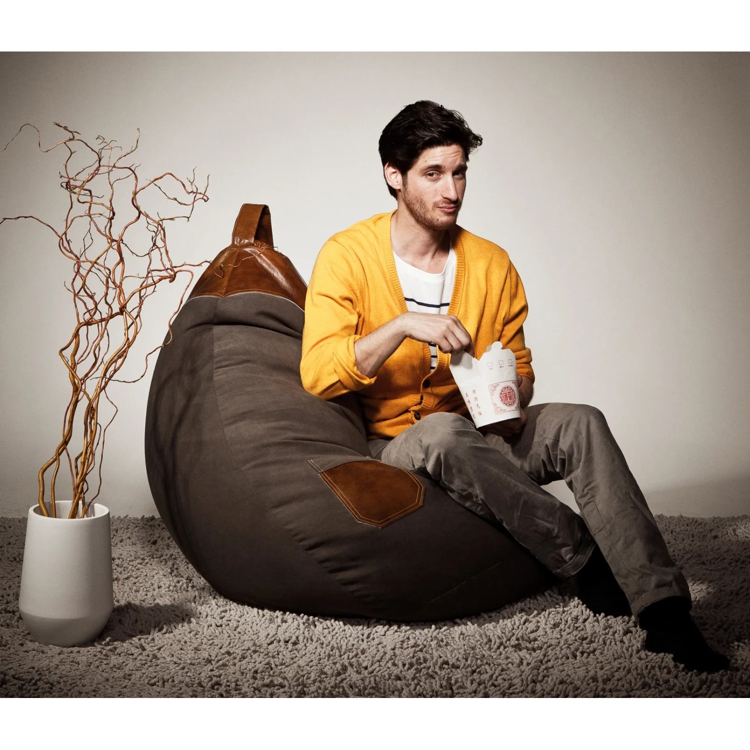 Brauner Sitting Point Sitzsack Jamie (220 l) mit Mann beim Essen, ideal zum Relaxen.